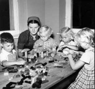 Arbeitsmaid des Reichsarbeitsdienstes bei der Kinderbetreuung im Kindergarten