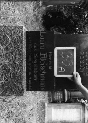 Grabstein 33 (Index: 99753476) Material: Granit Zustand: gut Maße HxBxT: 170x49x18 cm Beschreibung: getreppter Sockel, Stele, Giebel mit Eckakroteren Symbolik: Blütenfries: Grabstein 33A