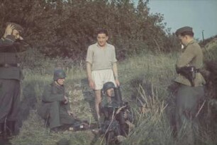 Zweiter Weltkrieg. Vier Wehrmachtsangehörige an einem Maschinengewehr (vermutlich während der Ausbildung)