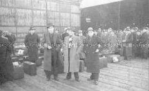 Selbstversenkung des Hochseepassagierdampfers "Columbus" am 19. Dezember 1939, während der Überführung von Besatzungsangehörigen vom Internierungslager auf Ellis Island in das Internierungslager auf Angel Island, Kalifornien, hier wartend am Hafen für den Umstieg vom Zug auf einen Dampfer