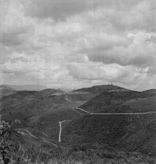 Hügellandschaft : Straße durch eine Hügellandschaft, auf einer Kuppe Lubero