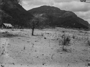 Landschaft : Blick über eine Trockenebene. Im linken Bildrand wird vermutlich das Lager der Forschungsreisenden aufgebaut. Im Hintergrund Berge