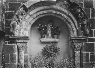 Archivoltenfiguren Löwe mit Akrobat und Halbfigur