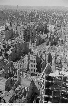 Blick über Ruinen, Bauarbeiter auf einem zerstörten Gebäude