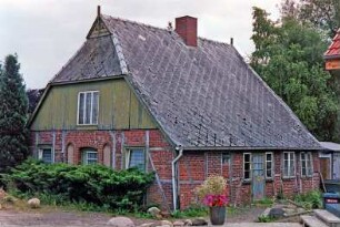 Beektwiete 3: giebelständige Fachwerkkate: Straßenfront ehemaliger Wirtschaftstrakt, mit Umbauten, oben Verbretterung, Giebelzier, Eulenlöcher: Traufseite mit Eingangstür, rechts Wohntrakt: davor Hecken