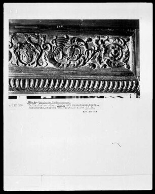 Teilaufnahme einer Truhe mit Reliefschnitzerei, Rankenwerk, Drachen und Wappen