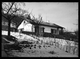Weiß verputzes Haus am Hang im Schnee [Hasloch]