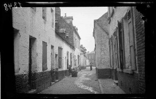 Mons (Belgien): gepflasterte Gasse mit niedrigen, weiß gestrichenen Hauswänden ("Straßenbilder aus dem Stadtteil der ärmeren Bevölkerung")