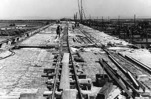 Rheinbrücke Frankenthal (Theodor-Heuss-Brücke), km 565,185 - 566,014 Nachbehandeln der Betonfahrbahndecke, Abdecken mit Strohmatten Baubeginn: Oktober 1938, Einsturz der Stahlbrücke: 12.12.1940, Einstellung der Arbeiten: Ende 1941,Weiterbau: April 1949, Verkehrsübergabe Fahrbahn Mannheim - Saarbrücken: 9.9.1950, Bau der Fahrbahn Saarbrücken - Mannheim: August 1960 -September 1963. Endgültige Fertigstellung: 12.6.1964.