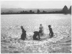 Kinder spielen im Wasser (Altersgruppe bis 14)