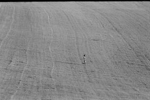 Čičmany. Akt-Pleinair 1980. Abgeerntetes Feld mit einer darüber laufenden jungen Frau
