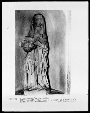 Weibliche Heiligenfigur mit Brot und Obstkorb (Heilige Elisabeth von Thüringen?)