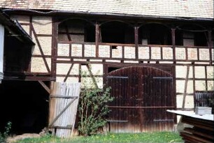 Scheune mit Laubengang, Fachwerk mit Tuffstein ausgesetzt; in Brüstungsfeldern Initialen FM und Jahreszahl 188?