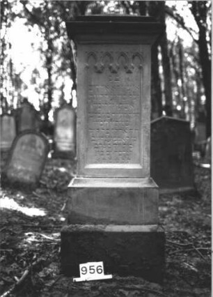 Grabstein 956 (Index: 99899481) Material: Sandstein Zustand: Vorderseite gut erhalten Maße HxBxT: 178x64x39 cm Beschreibung: aufgesockelte Stele mit Verdachung, über der Inschrift Spitzbogenfries Symbolik: Spitzbogenfries: Grabstein 956