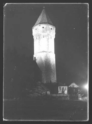 Spitzer Turm mit kleinen Hütten bzw. Häusern davor