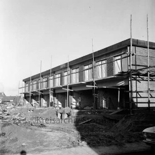 Wikingerweg: Wohnungsbau: Reihenhäuser im Rohbau mit Gerüsten: vorn Baumaterial: hinten links Einfamilienhäuser: rechts Schatten