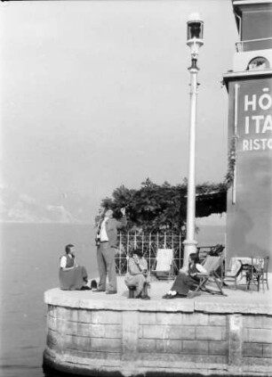 Malcesine: Gardasee, Hafeneinfahrt mit Kai und Liegestühlen