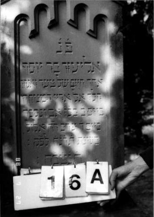 Grabstein 16 (Index: 100110209) Material: Sandstein Zustand: leicht verwittert Maße HxBxT: 169x54x24 cm Beschreibung: Stele, getreppter Sockel, giebelartiger Abschluß mit Verdachung und Mittelakroter Symbolik: ornamentales Akroter, gestelztes Rundbogenfries: Grabstein 16A