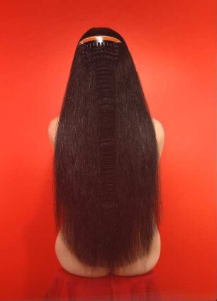 Sitzende mit langen schwarzen Haaren. Rückenansicht