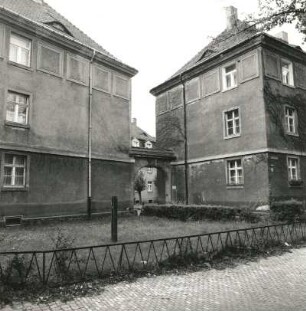Dresden-Trachau. Wohnsiedlung des Bauvereins Kleinwohnungsbau (1919/1921; O. Schubert). Wohnanlage mit Torbogen, Wilder-Mann-Straße 21 d/Kopernikusstraße 15. Straßenansicht mit Einfriedung