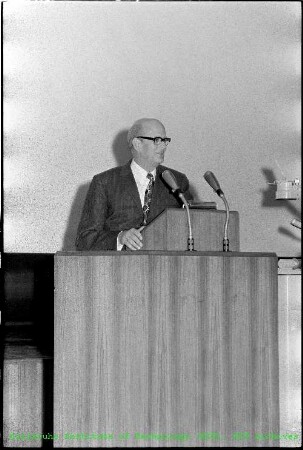 Prof. Karl Wirtz (Leiter des Instituts für Neutronenphysik und Reaktortechnik (INR)) an einem Rednerpult in der Aula der Schule für Kerntechnik (SKT)
