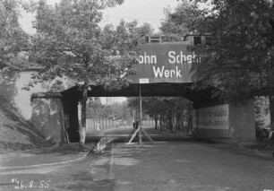Eisenbahnbrücke der Grubenbahn zum Industrie-Kraftwerk Lauta über eine Dorfstraße. Ansicht in Richtung Längsachse der Straße, unter der Brücke Holzgerüst mit Meßstellen für das (Durchbiegungs-?)Verhalten des Brückenüberbaues : Laubusch (Niederlausitz). Eisenbahnbrücke der Grubenbahn zum Industrie-Kraftwerk Lauta über eine Dorfstraße. Ansicht in Richtung Längsachse der Straße, unter der Brücke Holzgerüst mit Meßstellen für das (Durchbiegungs-?)Verhalten des Brückenüberbaues