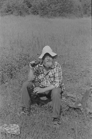 Čičmany. Akt-Pleinair 1980. Der Fotograf Roger Rössing mit Fernglas auf einer Wiese sitzend