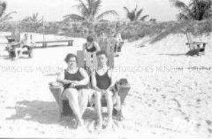 Touristen am Strand in einem Doppelliegestuhl