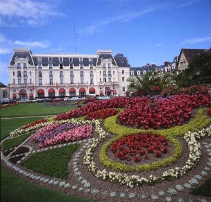 Frankreich/Département Calvados. Cabourg, Les Jardins du Casino. Grand Hôtel (1908 Entwurf; Lucien Vieraut, Émile Mauclerc). Blick über eine Blumenanlage