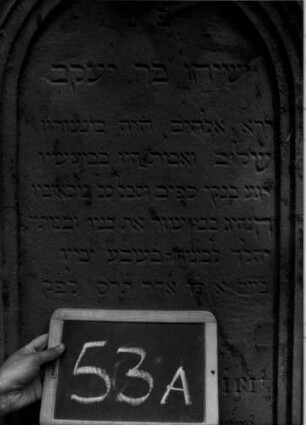 Grabstein 53 (Index: 100109988) Material: Sandstein Zustand: leicht verwittert Maße HxBxT: 240x74x38 cm Beschreibung: Stele, getreppter Sockel, Giebel, Schriftfeld mit Rundbogenabschluß: Grabstein 53A