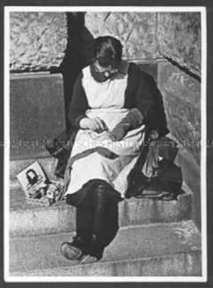 Frau stopft Socken (auf einer Treppe des Arbeitsamtes Hannover?)
