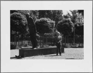 Mann vor der Skulptur "Zur Schicht" (1983) von Waldemar Otto, Bremen-Gröpelingen, Ecke Lindenhofstraße/Dockstraße : Denkmal zur Erinnerung an das Arbeitsleben sowie die politischen Kämpfe und Werftbesetzung der Werftarbeiter der AG Weser