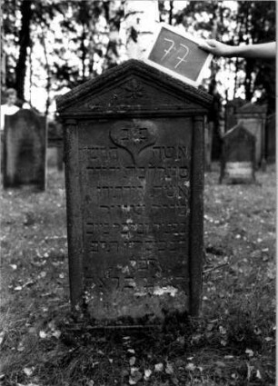 Grabstein 77 (Index: 100111160) Material: Sandstein Zustand: leicht verwittert Maße HxBxT: 122x62x13 cm Beschreibung: ädikulaartige Stele mit Halbsäulen, Sockel, Giebel mit Verdachung Symbolik: Herz, Blüte: Grabstein 77