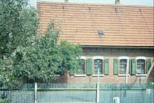 eingeschossiges Backsteinhaus mit Fensterläden