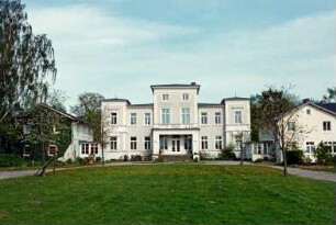 Gut Wulksfelde: ehemaliges Herrenhaus: Straßenfront mit Mittelrisalit, Freitreppe, Vorbau mit eingezogenem Eingangsportal, darüber Altan, zwei Eckrisaliten: beiderseits Kavalierhäuser mit verglasten Eingangsveranden: vorne Vorplatz, junge Bäume, Auffahrt: 9. Mai 2003