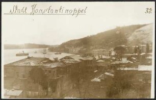 Blick auf einen Stadtteil Istanbuls auf europäischer Seite im Winter, Gebäude mit schneebedeckten Dächern und Straßenzüge am Bosporus, einige Schiffe, rechts Hügel