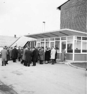 Reinfeld: Kreistagssitzung am 13. Februar 1962: Besichtigung der "Opal-Werke", Strumpffabrik Margaritoff & Schaffer GmbH: Kreistagsabgeordnete vor dem Eingang zum Werksgebäude