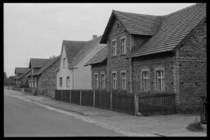 Dorfstraße mit verputztem Haus