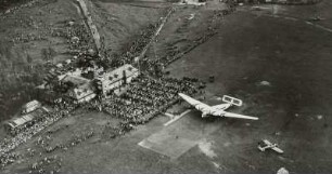 Flugplatz Dresden-Heller, Verkehrsflugzeug Junkers G 38 am Flugtag auf dem Rollfeld mit Zuschauern vor dem Abfertigungsgebäude mit Kontrollturm, Luftbild-Schrägaufnahme