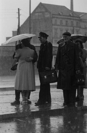 Im Regen wartende Personen