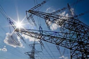 Atomkraftwerk AKW Grafenrheinfeld. Sonne mit Hochspannungs-Leitungen und -Masten. Symbol für Energie