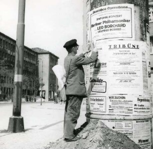 Berlin. Anbringen von Plakaten an einer Litfaßsäule (u. a. ein Konzert der Berliner Philharmonie am 25.08.1945 mit Siegfried Borris, Leitung Leo Borchard), Sommer 1945