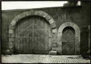 Langgasse 94. Tor 1722, Scheitelstein mit 3 Fratzen Engelsköpfchen, Fabeltiere, Köpfe aut den Gewänden. Nebenpforte mit Mühlrad im Schlußstein