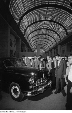 Besucher der Leipziger Herbstmesse 1954 begutachten einen ausgestellten PKW der sowjetischen Sektion
