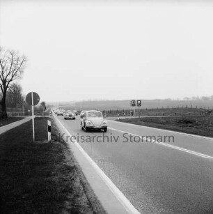 Nütschau: Bundesstraße B 404: Ausflugsverkehr: hinten Pkws: hinten rechts Abzweigung Schlossstraße mit Hinweisschildern Polizei und Unfallhilfsstation: hinten links Abzweigung Schlossstraße mit Hinweisschild Kloster Nütschau