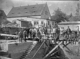 Brückenbauer vor der Brückenbau-Schänke : Das Blaue Wunder in Loschwitz im Bau. Brückenbauer vor der Brückenbau-Schänke. Fotografie (1891/1892; A. Kotzsch). Dresden: Privatbesitz