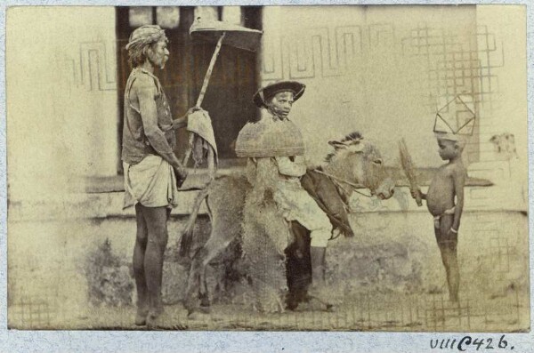 Man and two children, one riding a donkey