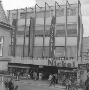 Kaufhaus Nickel: Mühlenstraße: Neubau mit Schaufensterfront und Werbebannern: davor Fußgänger: vorn Einmündung der Hindenburgstraße