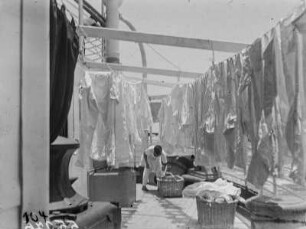 Chinesische Wäscherei an Bord des Dampfers "Usambara" (Deutsche Ost-Afrika-Linie). Weißwäsche zum Trocknen auf dem Deck, im Hintergrund Wäschereiarbeiter, 1931