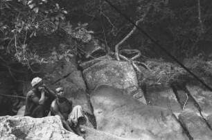 Felsen im Mtumbei-Fluss bei Namjani : Dschungellandschaft mit zwei Männern auf Felsen